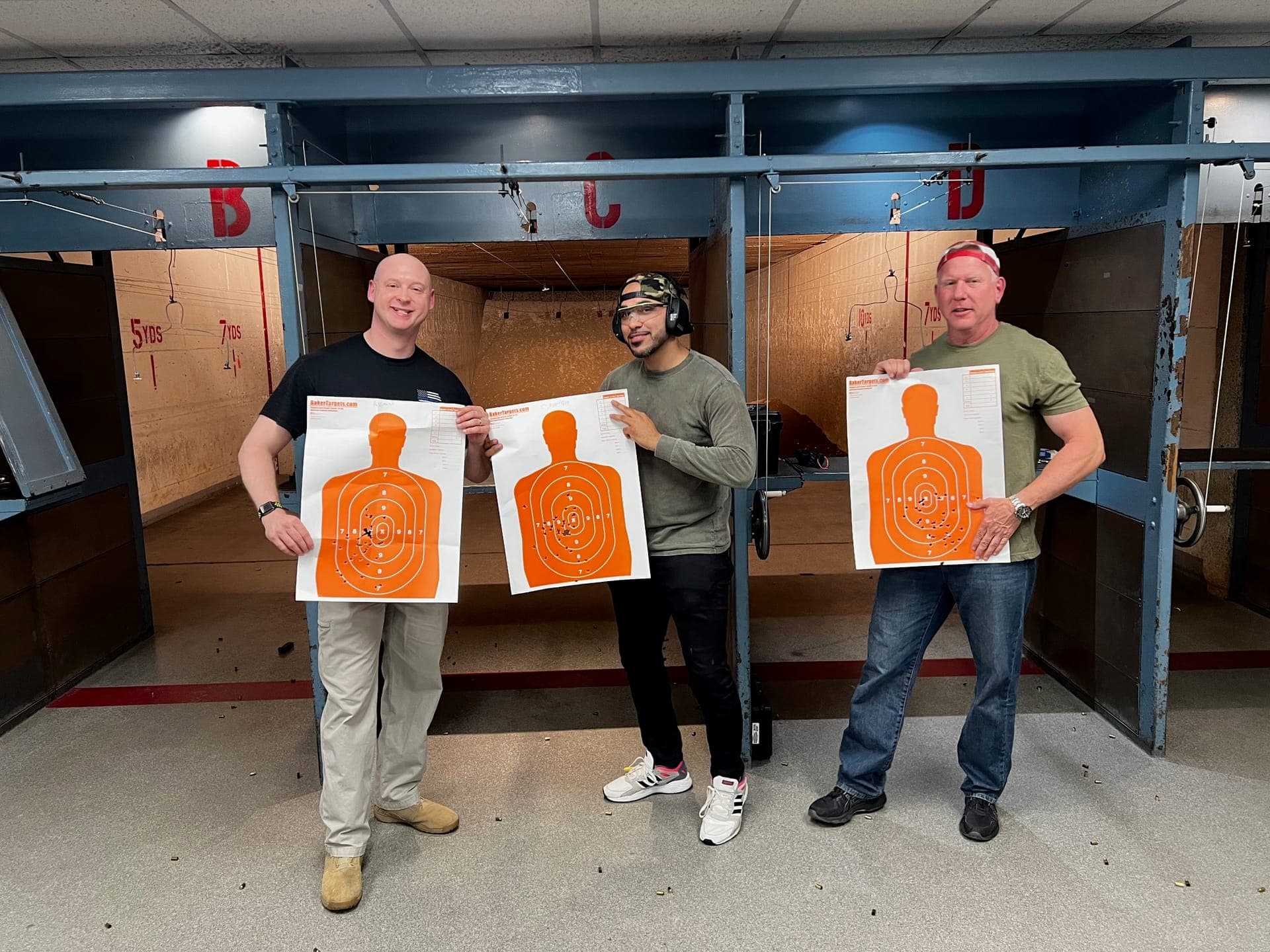 Students proudly displaying orange target results at the range