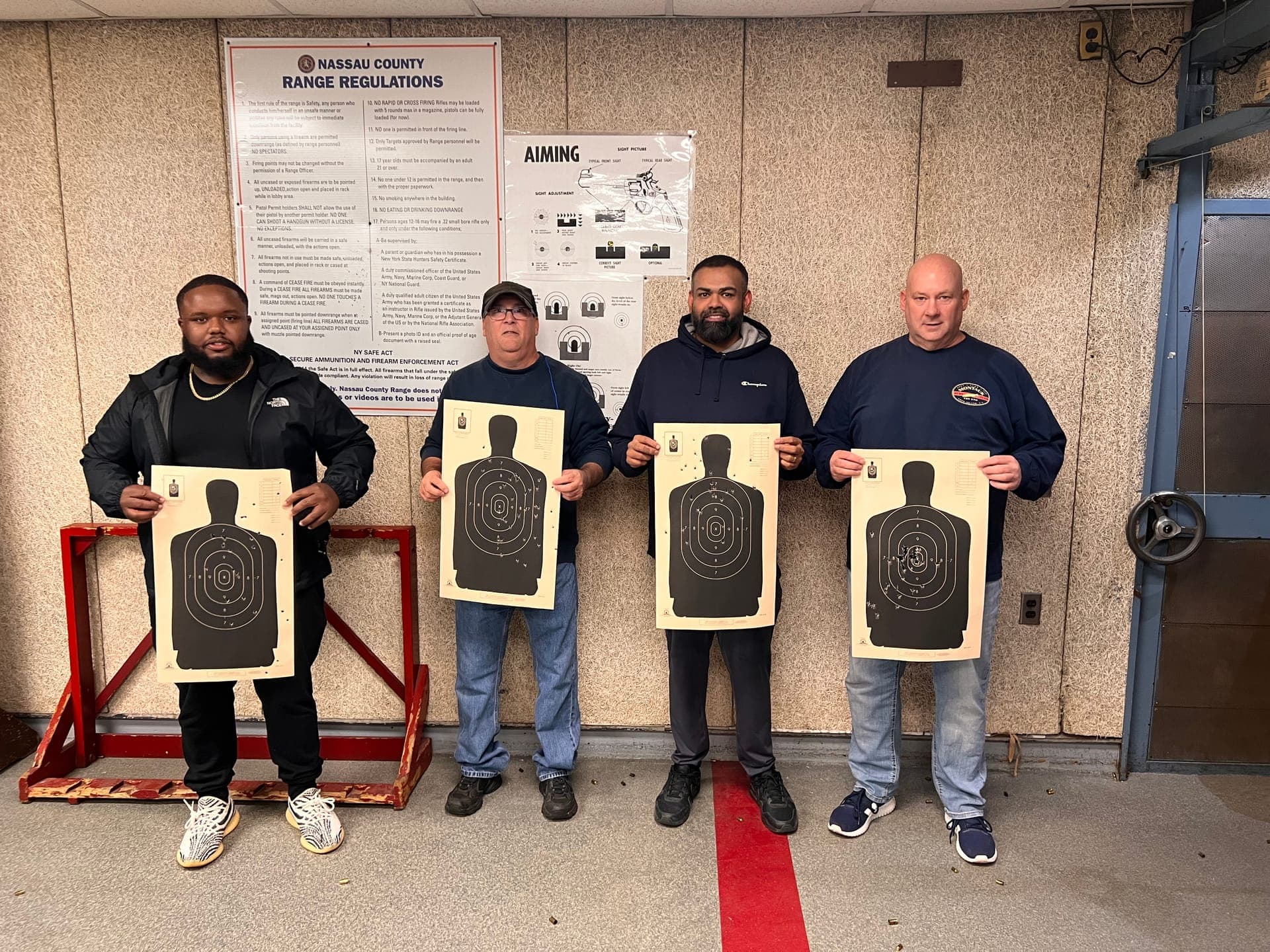 Students holding targets at Nassau County range after training session