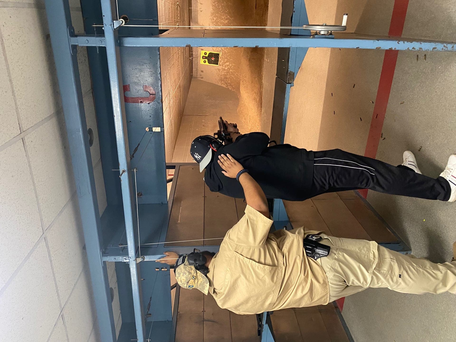 Live fire exercise — instructor guiding student at shooting position