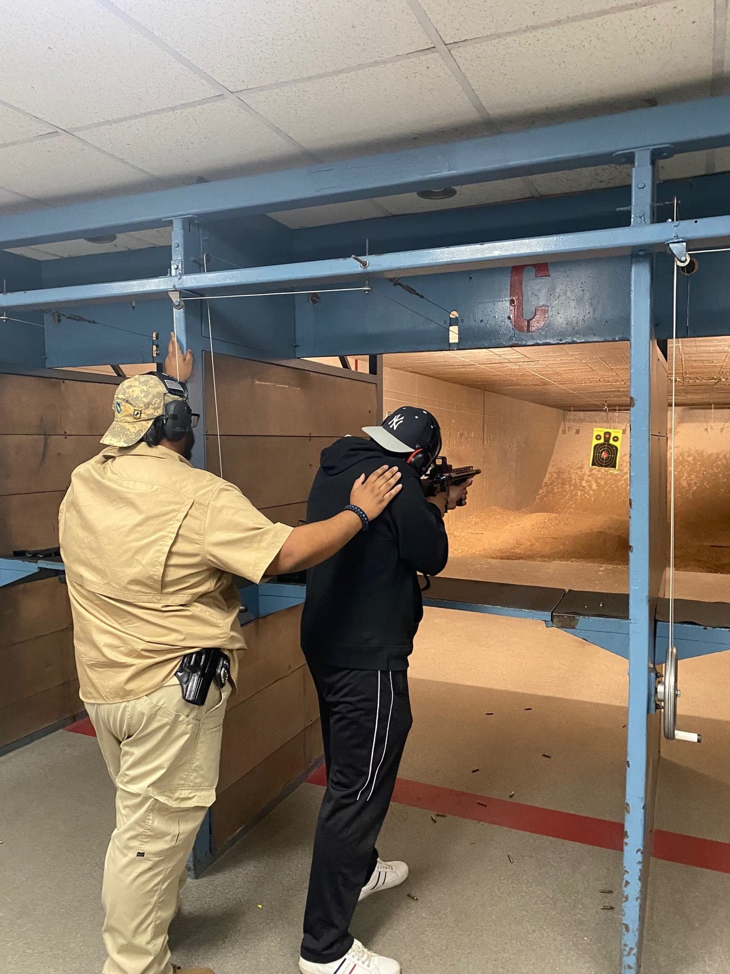Live fire exercise — instructor guiding student at shooting position